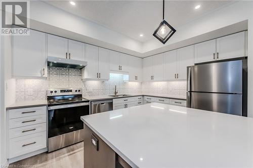 Kitchen featuring white cabinets, light wood-type flooring, and stainless steel appliances