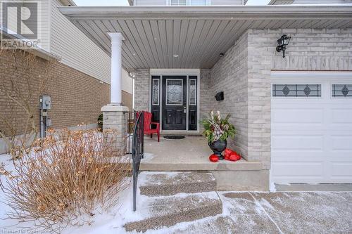 Snow covered property entrance with a porch and a garage