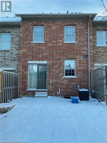 Snow covered back of property featuring central AC