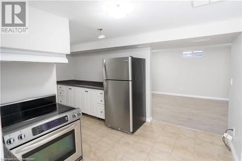 Kitchen featuring light hardwood / wood-style floors, white cabinetry, stainless steel appliances, and range hood