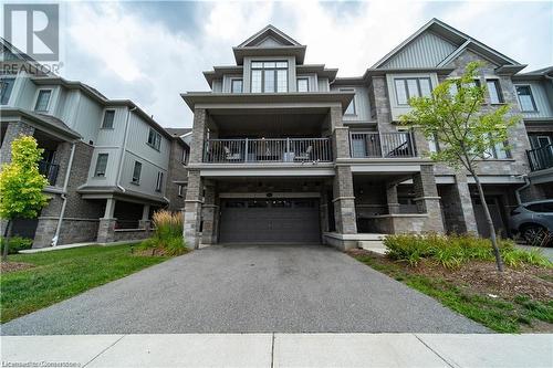 View of front facade featuring a garage and a balcony