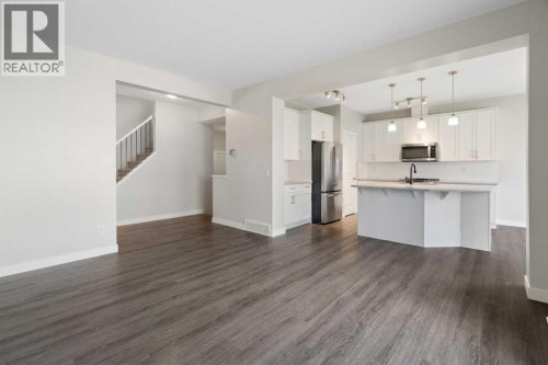 Vinyl plank flooring, high ceilings and view to kitchen